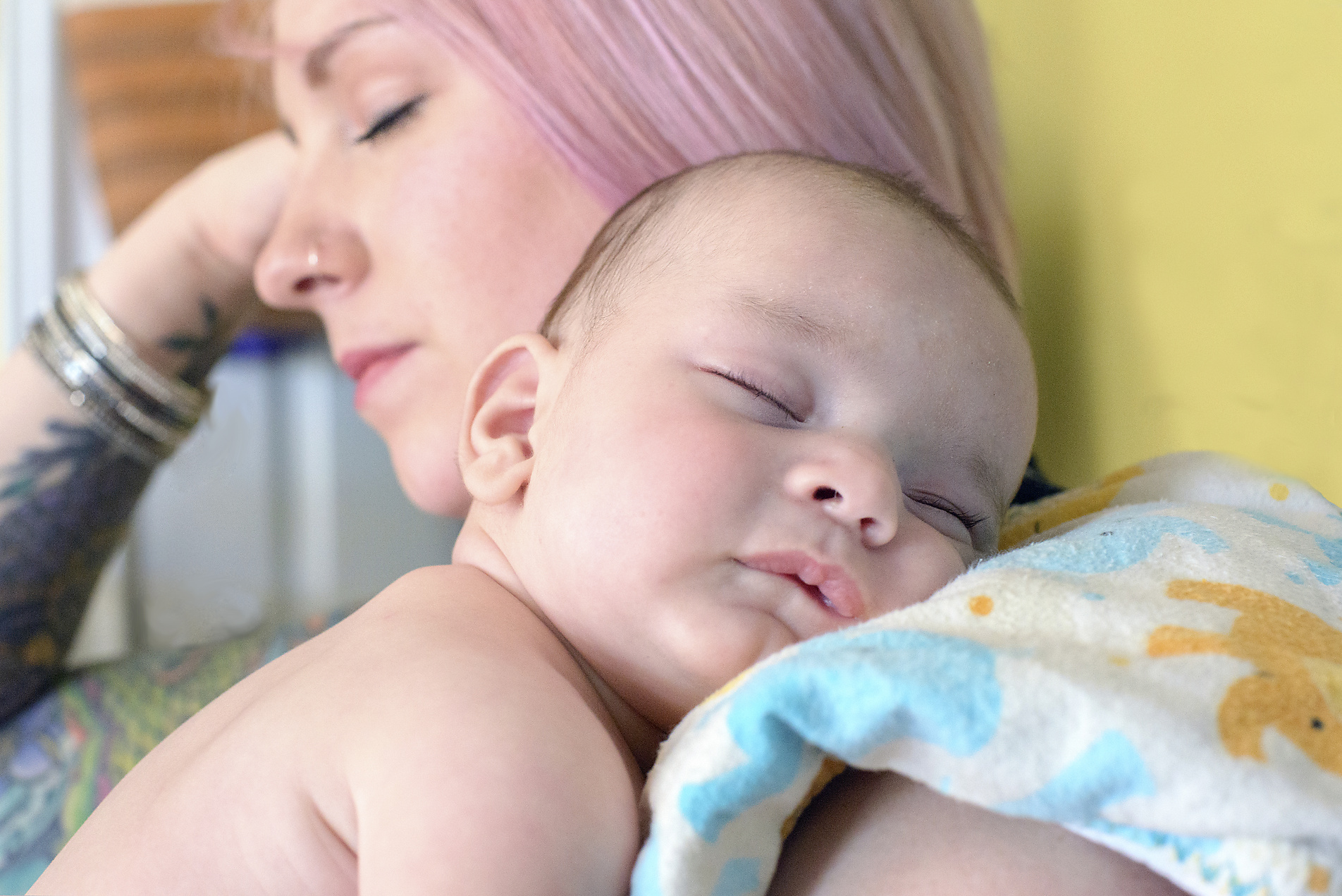 Mother peacefully holding sleeping baby with Cool Cuddle sling